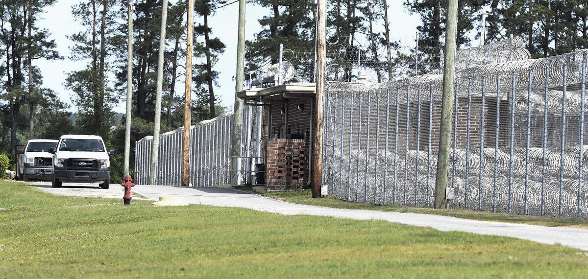 Prison officers in trucks patrol the perimeter fence at Neuse Correctional Institution, in Goldsboro, N.C.