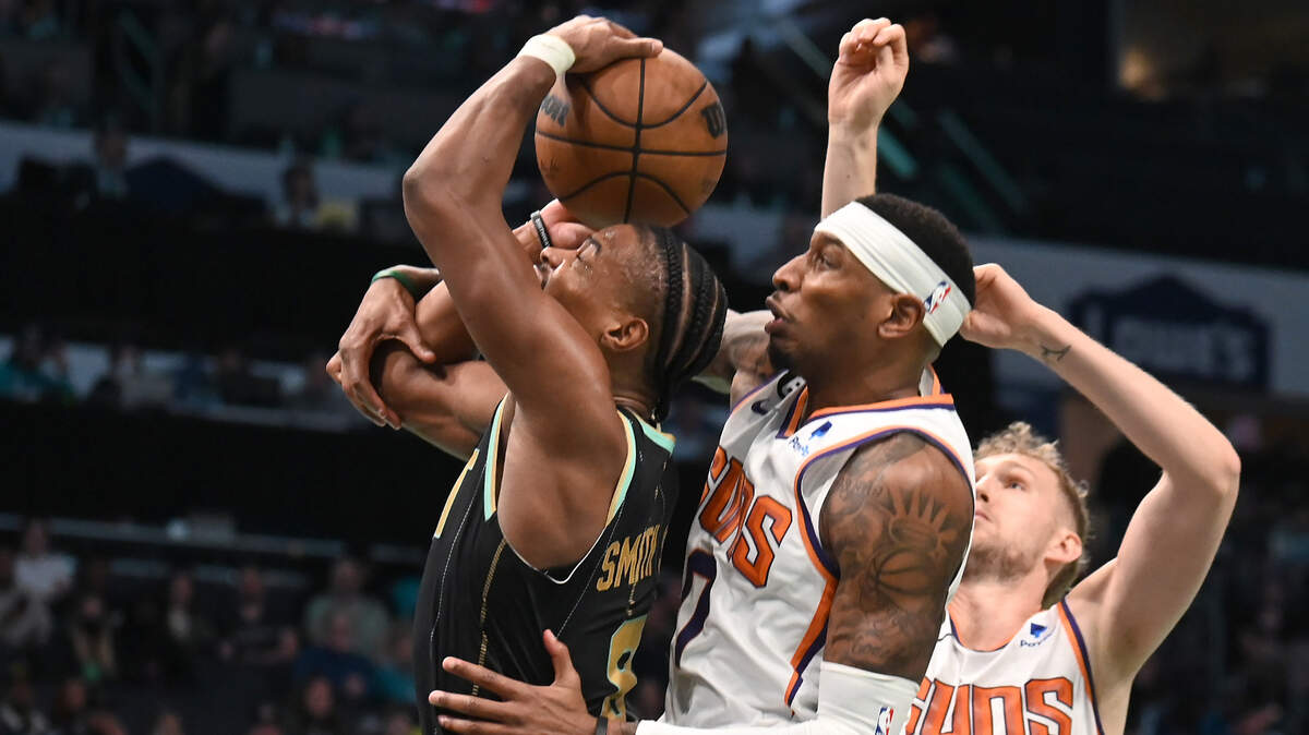 Charlotte Hornets guard Dennis Smith Jr., left, is fouled on a shot attempt by Phoenix Suns forward Torrey Craig, right, during second half action at Spectrum Center on Wednesday, February 1, 2023.
