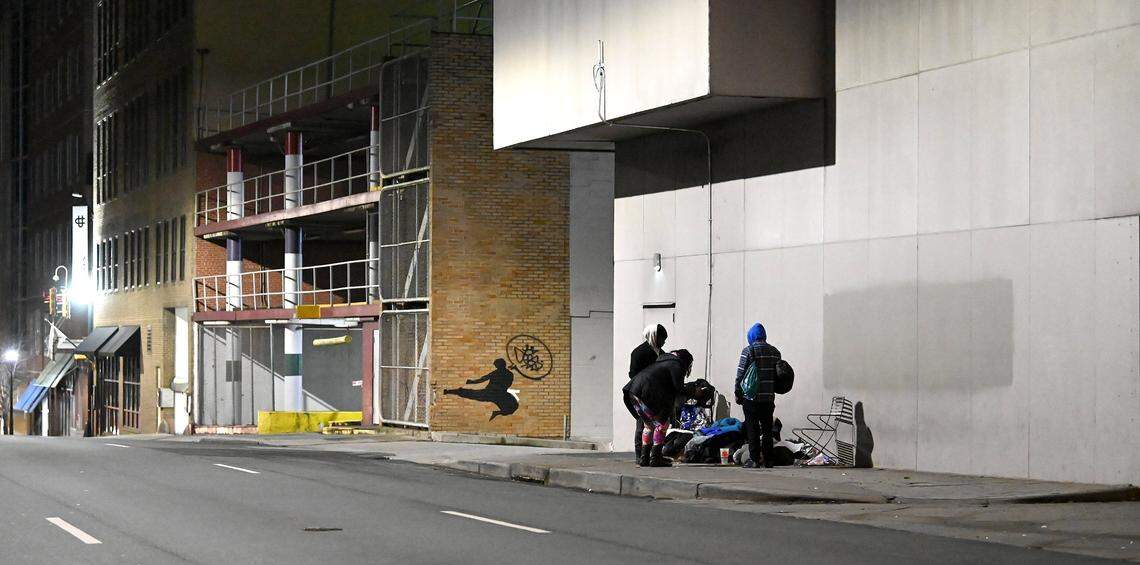 Point-in-Time Count volunteers Jerald Collins, left, Jeanelle Perry, center, and Joe Hamby, right, speak with a person who is homeless along Church St. in uptown Charlotte, NC., on Thursday, January 26, 2023. Volunteers aim to get an accurate statistic of how many people in Charlotte are homeless, live in shelters or tents or cars, or otherwise have unstable housing arrangements.