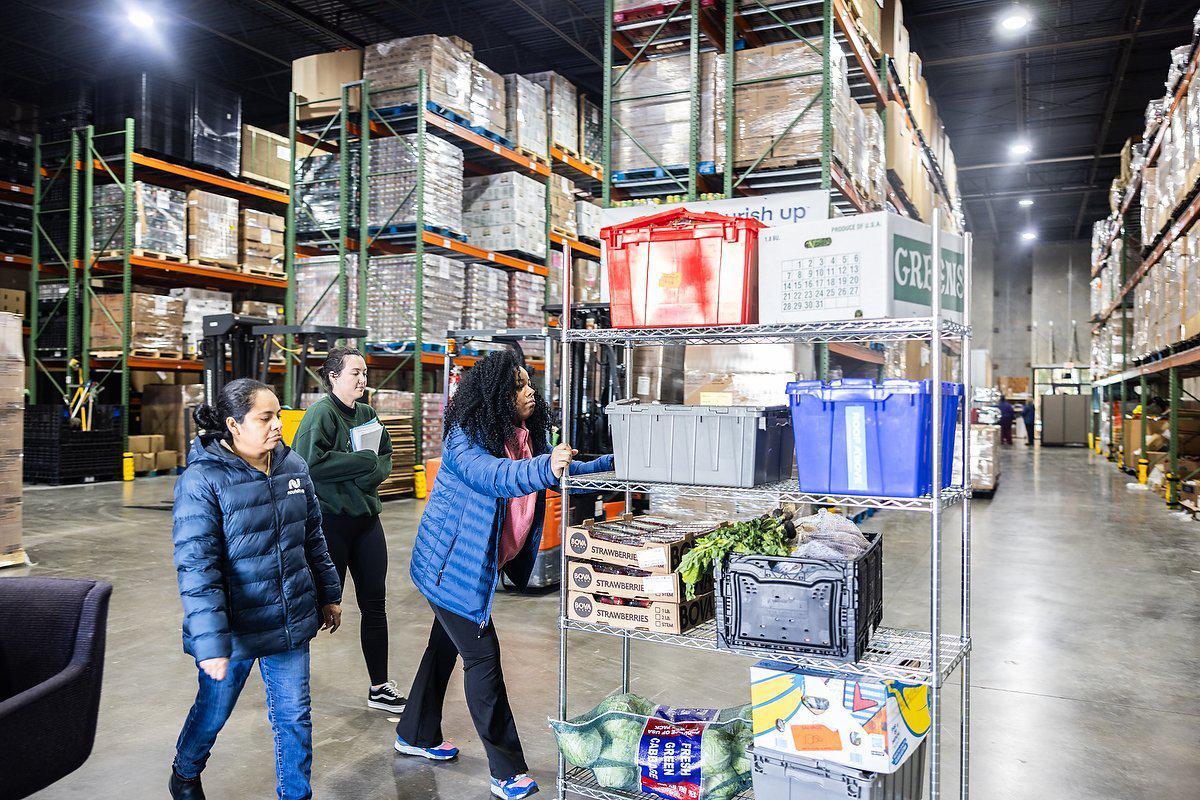 Volunteers work in the warehouse of the Nourish Up food pantry in Charlotte, N.C., on Tuesday, March 19, 2024.