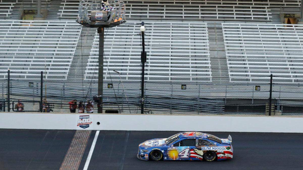 Kevin Harvick takes the checkered flag to win a NASCAR Cup Series auto race at Indianapolis Motor Speedway in Indianapolis, Sunday, July 5, 2020. (AP Photo/Darron Cummings)