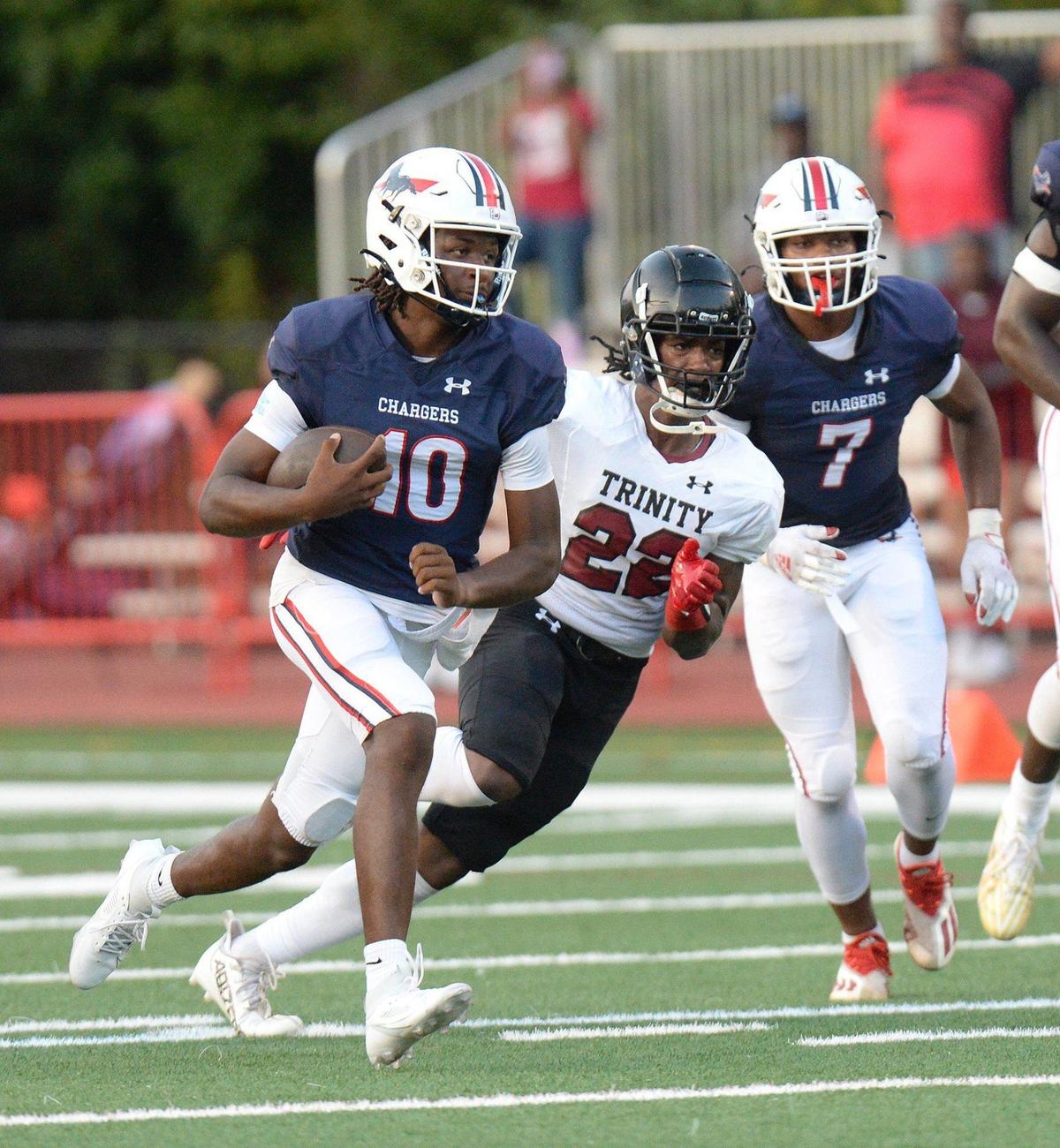 Providence Day quarterback #10, Zaid Lott, runs the ball under pressure in the first half Friday against Trinity Christian. Providence Day lead Trinity Christian 24-0 with 2:30 left in the first half. The Trinity Christian Crusaders came to Charlotte from Fayetteville, N.C. to face off against the nationally ranked Providence Day School Chargers in the first game of the high school football season on Friday, August 16, 2024.