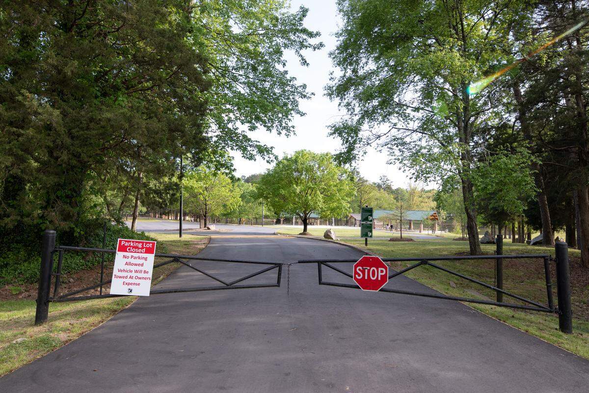 Every park in Mecklenburg County has a gate and sign up, just like this one at Park Road Park, informing drivers that parking lots are closed to the parks. Park Road Park only had a few visitors on the afternoon of April 11, 2020.