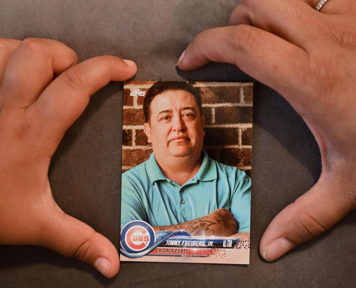The hands of Charley Freiberg and her mother, Vanessa Freiberg, form a frame around a trading card made in memory of Jimmy Freiberg.