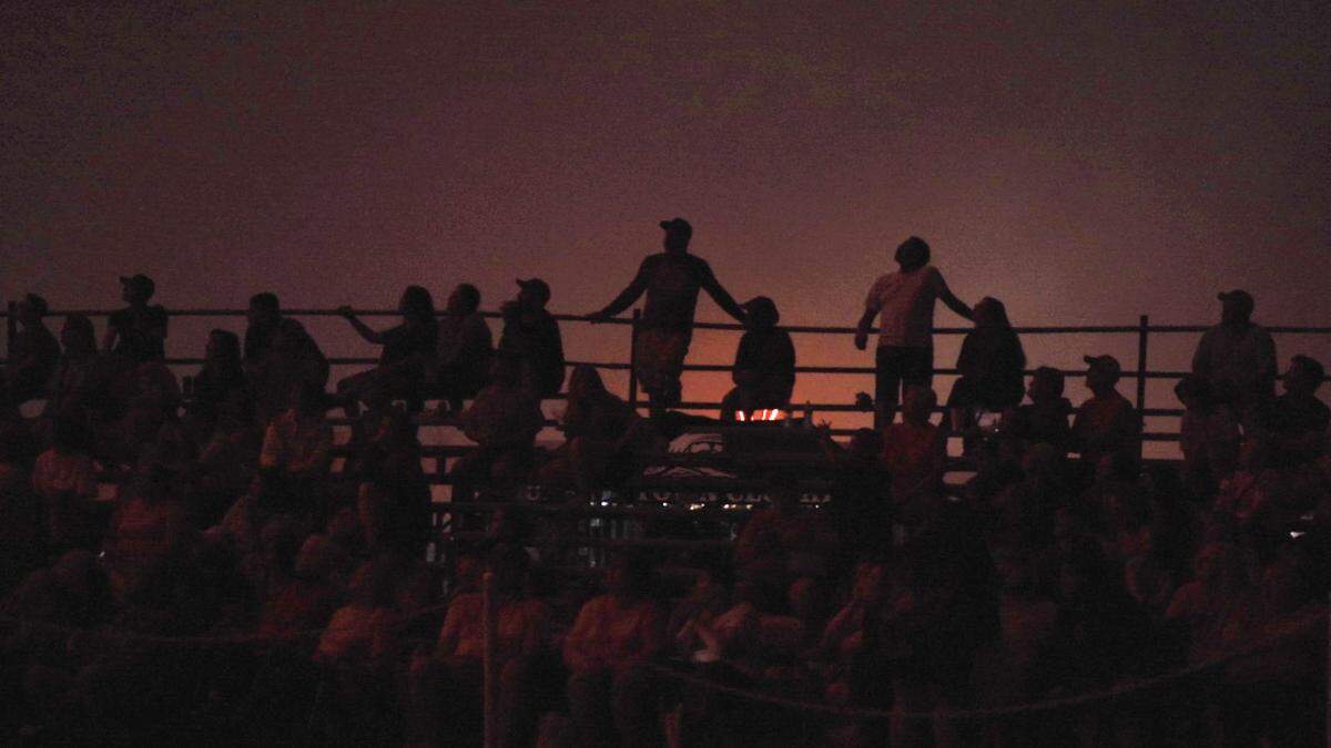 Illuminated by colorful flashes, spectators watch as fireworks launch over the 47th Annual 4th of July Powwow on Saturday, July 1, 2023 in Cherokee, NC.
