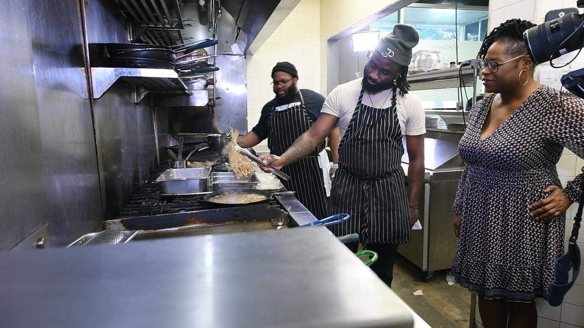 Jimmy Pears chefs Daryl “DC” Cooper and Oscar Johnson show CharlotteFive reporter Emiene Wright how to make croaker and potatoes, Virginia Tidewater-style, in February 2021.