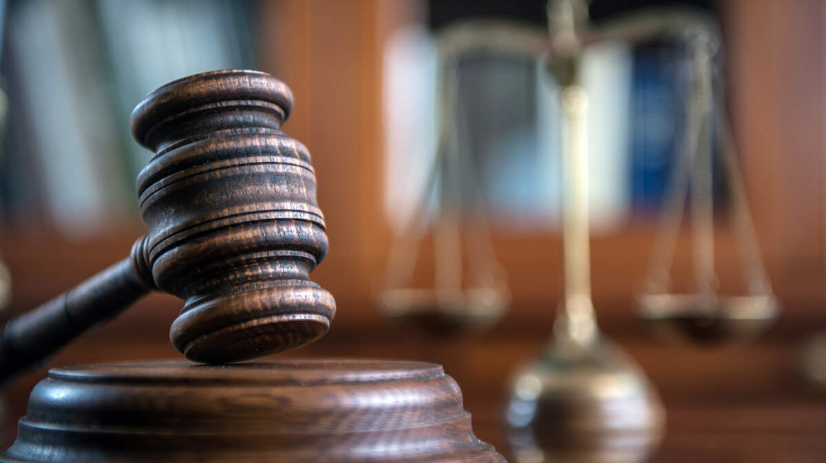 Law and Justice concept. Mallet of the judge, books, scales of justice. Gray stone background, reflections on the floor, place for typography. Courtroom theme.