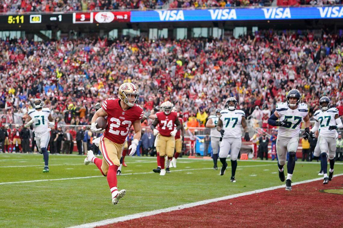 San Francisco 49ers running back Christian McCaffrey (23) scores a touchdown against the Seattle Seahawks during the first half of an NFL wild card playoff football game in Santa Clara, Calif., Saturday, Jan. 14, 2023.