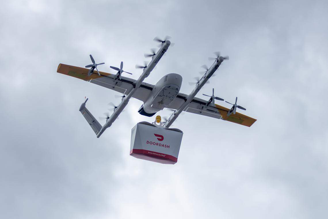 A Wing delivery drone, the 7000-WB, flies with a DoorDash delivery container. Wednesday, May 14, 2024, marked the first time drone delivery is available to homes in Charlotte.