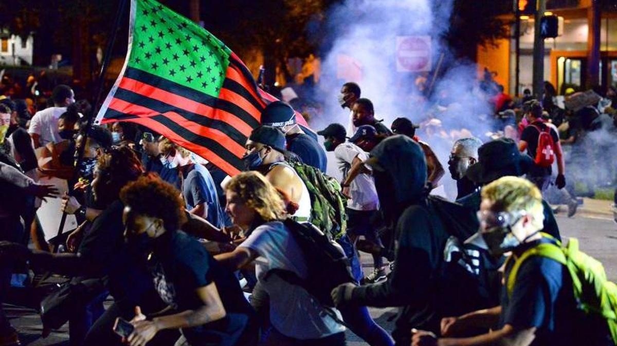 Protesters scatter after CMPD officers released chemical agents on people protesting peacefully over the death of George Floyd Tuesday night in uptown Charlotte.