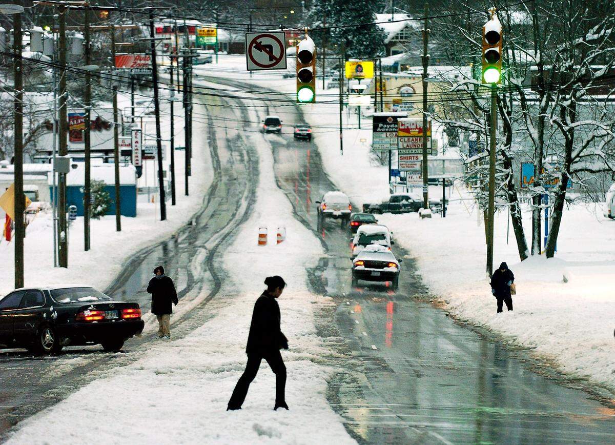 Residents try driving and walking on roads in snow-covered Charlotte on Friday, Feb. 27, 2004.