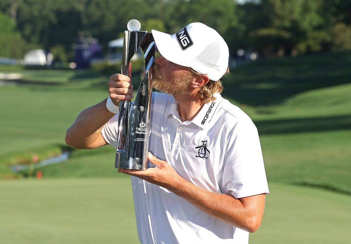 Golfer Kristoffer Reitan kisses the Truist Championship trophy at Quail Hollow Club in Charlotte, NC on Sunday, May 10, 2026. Reitan won the Truist Championship finishing at -15.