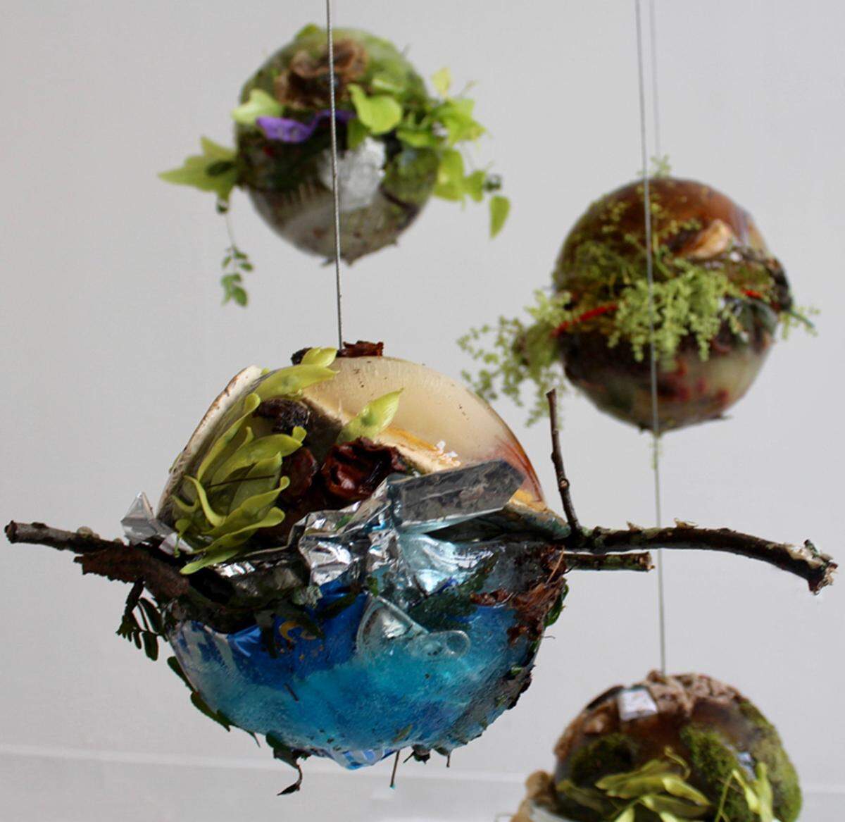This is a close up of “Wayside: Charlotte” by Katie St. Clair of Davidson. She won the $5,000 Young Affiliates of the Mint Choice Award at the Coined in the South juried art exhibition. St. Clair’s installation includes a set of spheres made of locally collected refuse and natural pigment held together by ice. The full frozen spheres are hung above a canvas and melt over time.