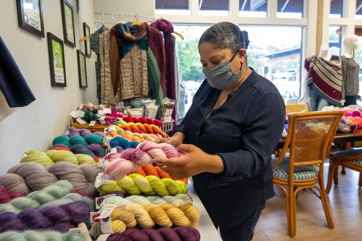 Remi Haygood organizes bundles of yarn at her Dilworth shop Charlotte Yarn.