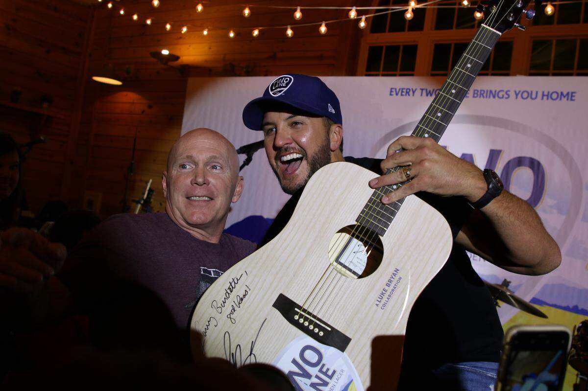 Luke Bryan poses with the winner of an auction for a signed guitar during the event on Tuesday evening. The sale price was $1,500, with all proceeds going to the Brett Boyer Foundation.