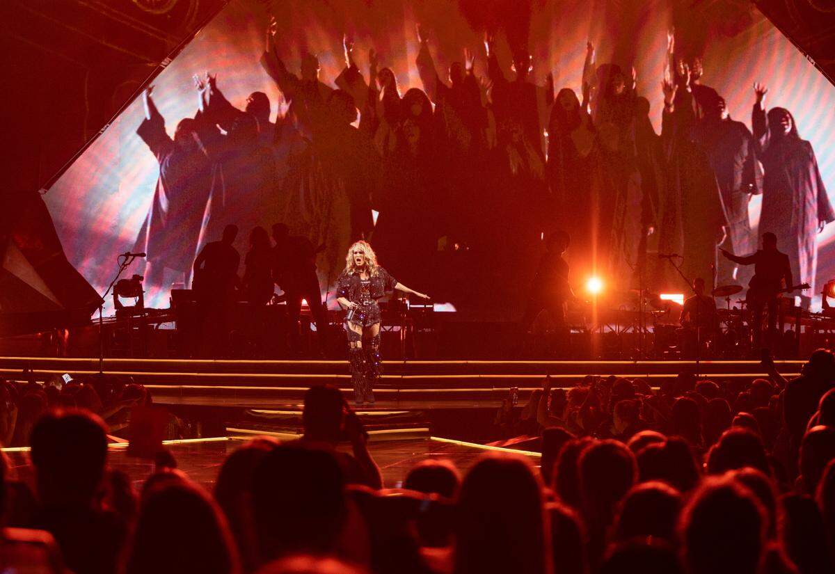 Carrie Underwood gestures to the crowd as she performs her song “Church Bells” at Spectrum Center in Charlotte on Wednesday night.