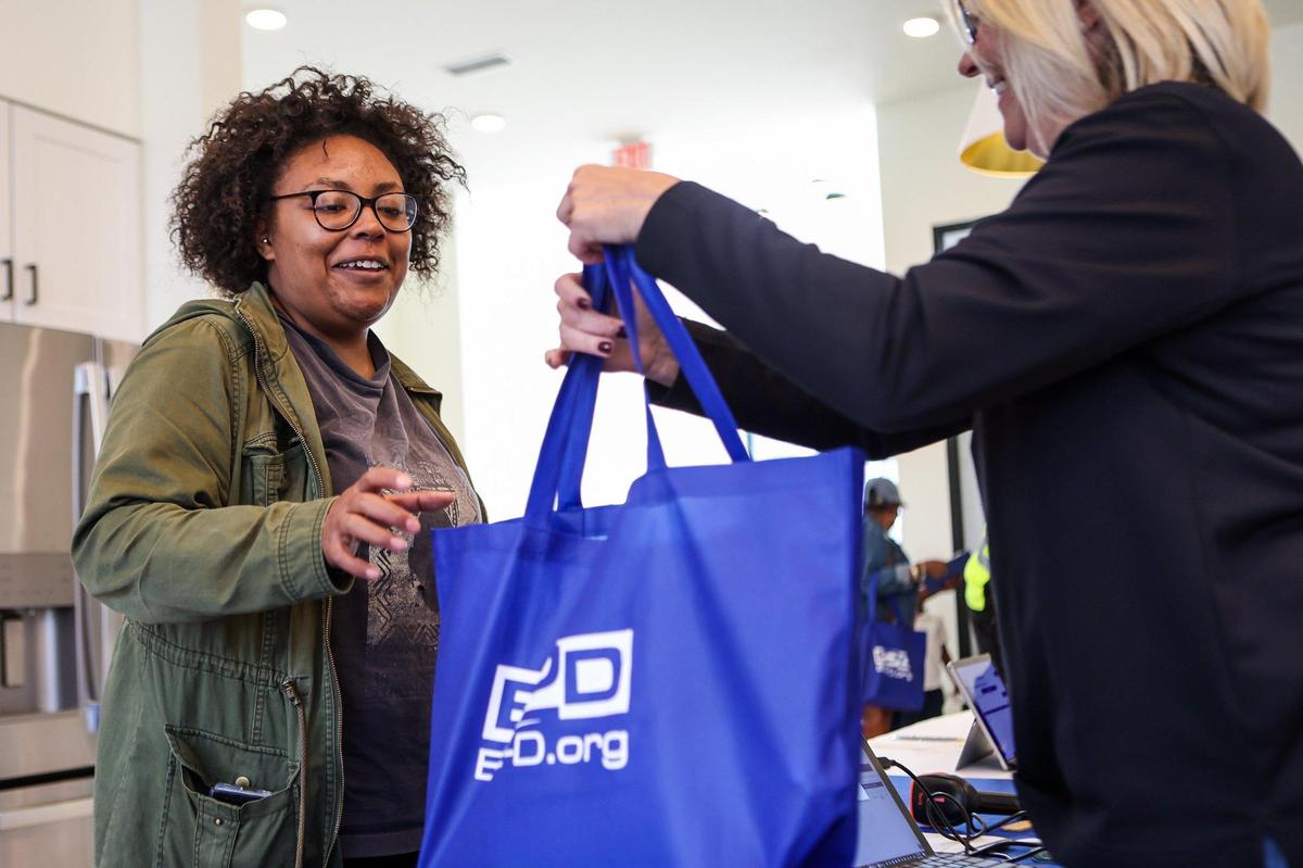 Nisa Allen, left, smiles as she receives a new Lenovo Think Pad laptop provided by E2D, the Center for Digital Equity, LISC, and Barings during a kick-off event at Evoke Living at Westerly Hills on Thursday, October 27, 2022.