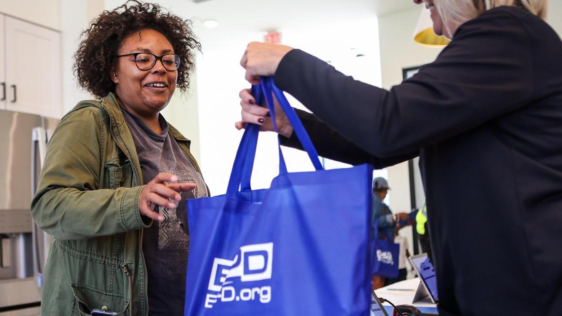 Nisa Allen, left, smiles as she receives a new Lenovo Think Pad laptop provided by E2D, the Center for Digital Equity, LISC, and Barings during a kick-off event at Evoke Living at Westerly Hills on Thursday, October 27, 2022.