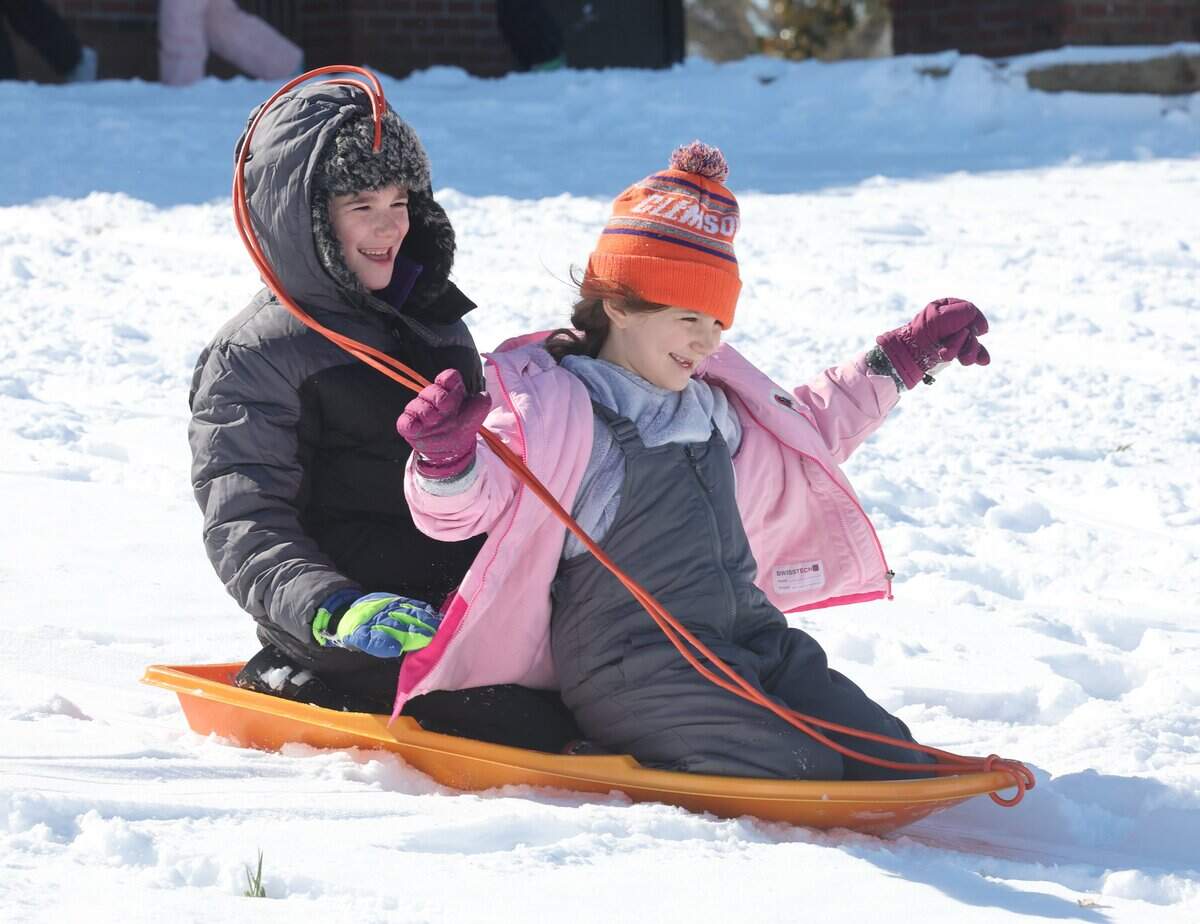 9-year-old William Brown, left, and 7-year-old Caroline Brown sled at the Winthrop Coliseum Sunday in Rock Hill.