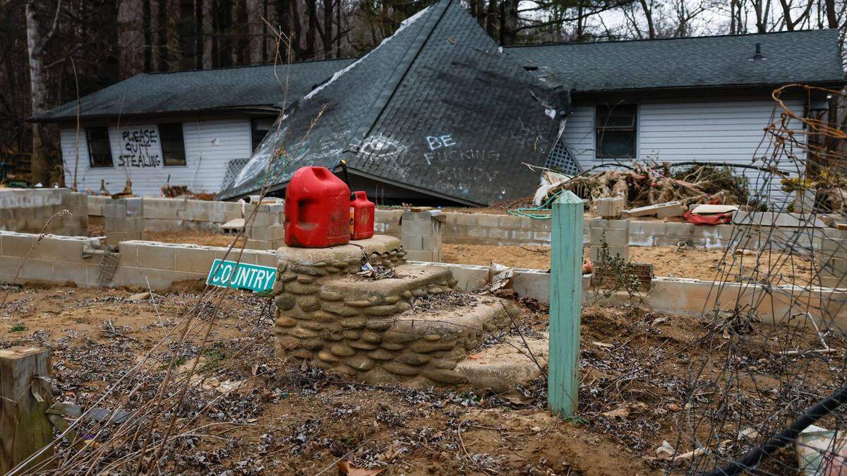 A gas canister sits atop steps that used to lead to the front porch of a Swannanoa home, which was moved off of its foundation by flood waters from Helene last year.