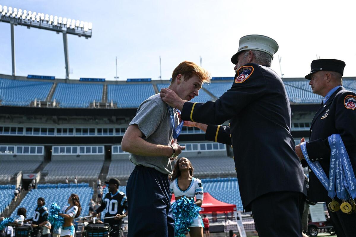 A participant receives a finishing medal after completing the Tunnel to Towers Tower Climb at Bank of America Stadium, Sunday, April 27, 2025, in Charlotte.