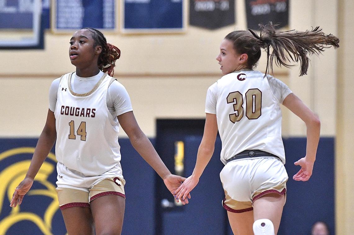 The Cannon School’s Madison Drayton (14) congratulates Brooke Busby (30) after her three-point shot during the first half. The Cannon School and Providence Day School met in the NCISAA 4A Girls Finals in Raleigh, N.C. on February 24, 2024.