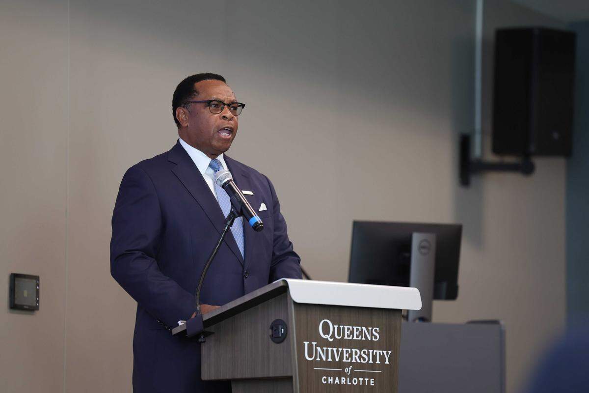 Queens Acting President Jesse Cureton announces Queens and Elon universities will merge next year during a press conference in Charlotte.