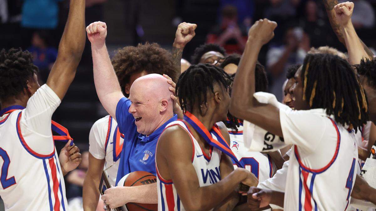 North Meck Vikings head basketball coach Duane Lewis, center, celebrates the team’s 57-47 victory over New Hanover with his team on Saturday, March 16, 2024. The Vikings won the NCHSAA 4A State Championship at Lawrence Joel Veterans Memorial Coliseum in Winston-Salem, NC.