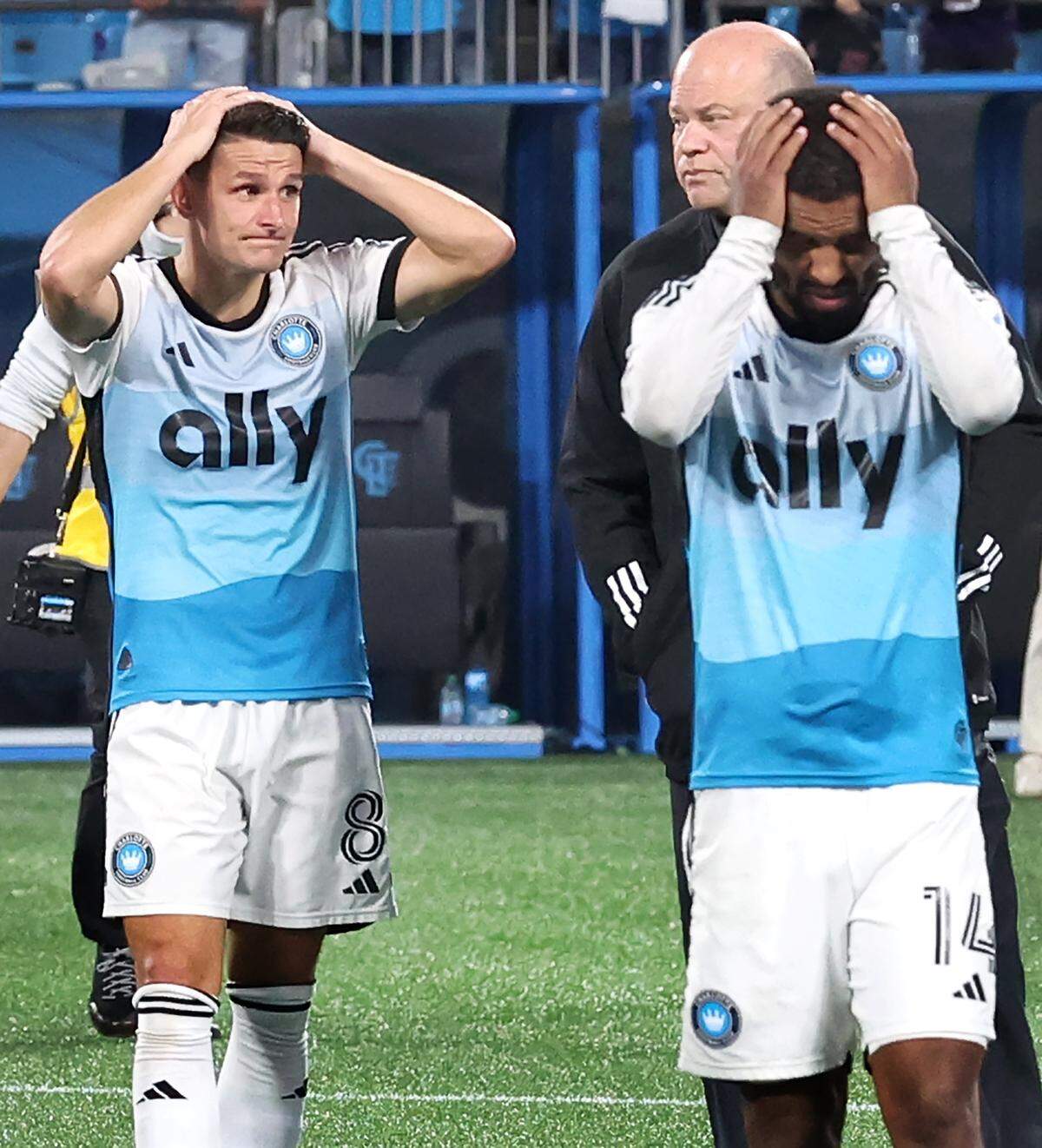 Charlotte FC central midfielder Ashley Westwood, left, and right back Nathan Byrne, right, walk off the pitch with team owner David Tepper after the team’s 3-1 loss to New York City FC in Game 3 of the MLS playoffs at Bank of America Stadium in Charlotte, North Carolina, on Nov. 7, 2025.
