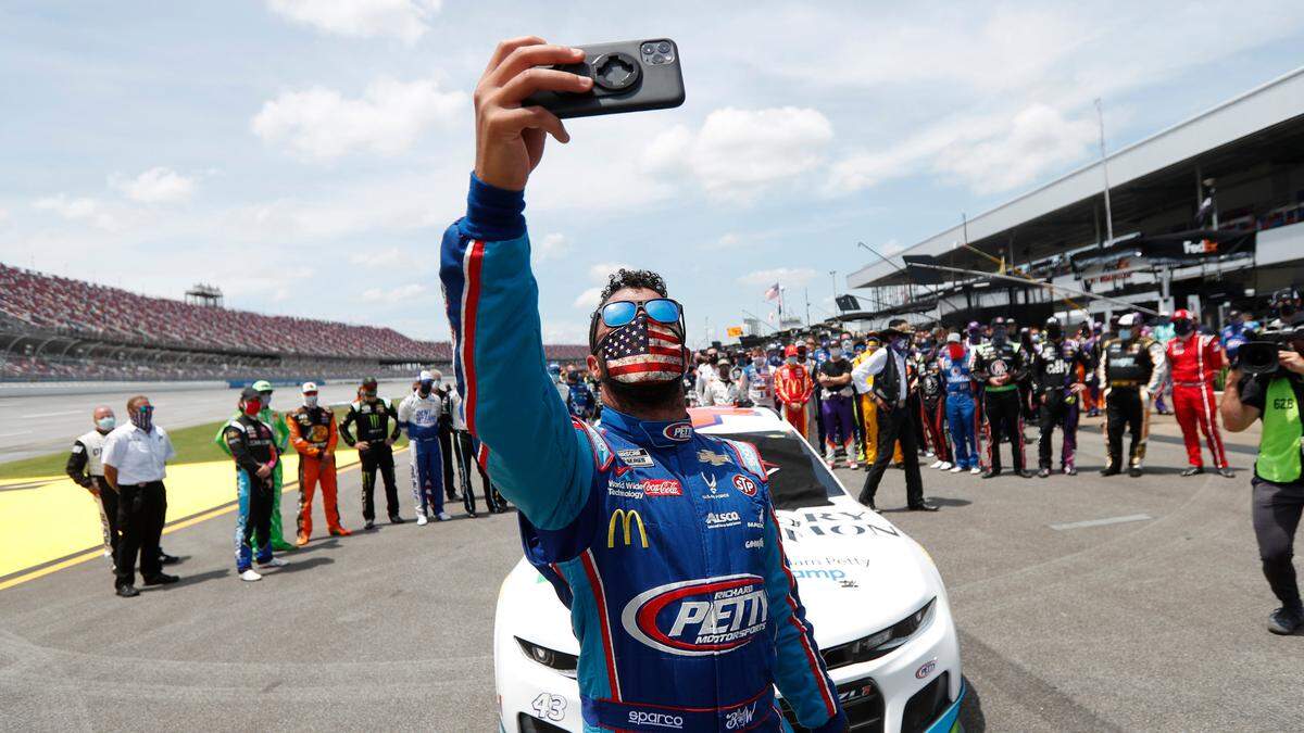 Driver Bubba Wallace takes a selfie with himself and other drivers that pushed his car to the front in the pits of the Talladega Superspeedway prior to the start of the NASCAR Cup Series auto race at the Talladega Superspeedway in Talladega Ala., Monday.