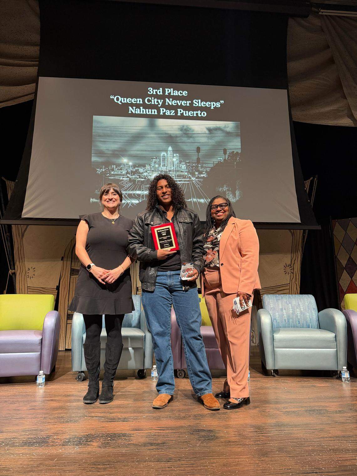 Nahun Paz Puerto, center, a student at East Mecklenburg High School, is honored as the third place winner of the student photo contest for his night landscape, “Queen City Never Sleeps”, during The Charlotte Observer’s third annual Captured Memories event at ImaginON: The Joe and Joan Martin Theater in Charlotte on Wednesday, January 14, 2026.