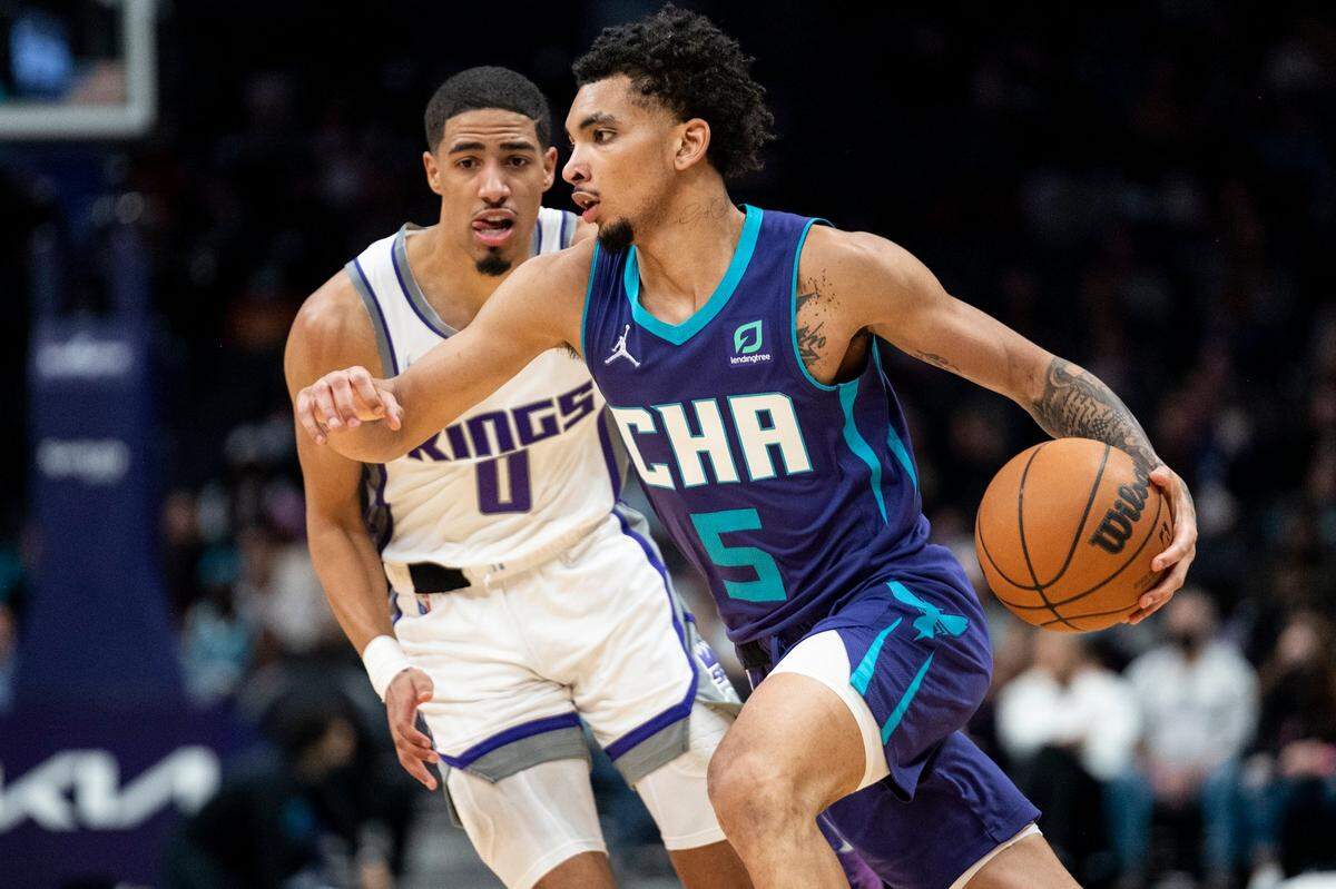 Charlotte Hornets rookie guard James Bouknight (5) drives past Sacramento Kings guard Tyrese Haliburton (0) during an NBA basketball game on Friday. Bouknight scored a career-high 24 points.
