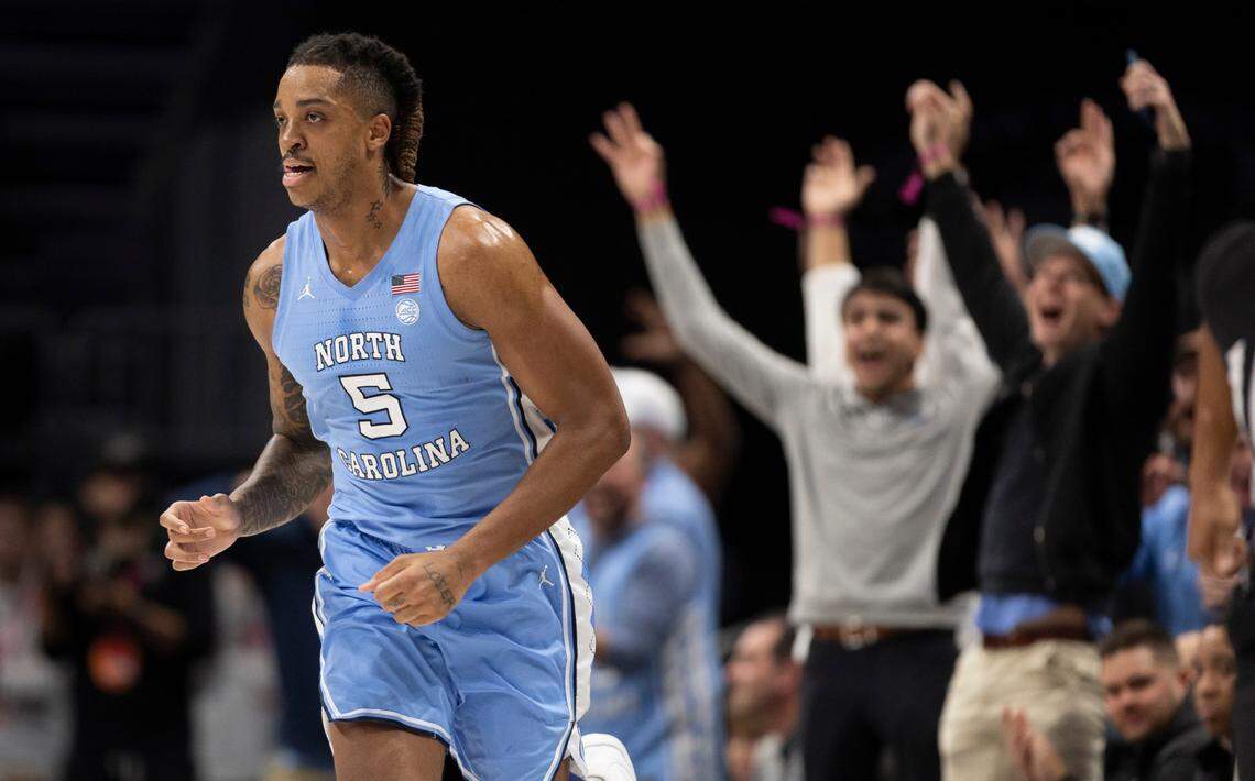 North Carolina fans seated court side celebrate after Armando Bacot (5) sank a three-point basket in the second half against Oklahoma on Wednesday, December 20, 2023 at the Spectrum Center in Charlotte, N.C. UNC beat No. 7 Oklahoma, 81-69.