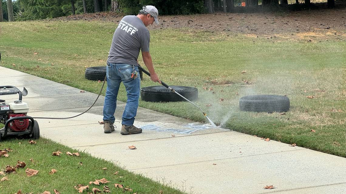 A worker at the Morrison Family YMCA sprays away hateful, antisemitic messages on its sidewalks last September. Recent data from the ADL found that antisemitism is on the rise in North Carolina.