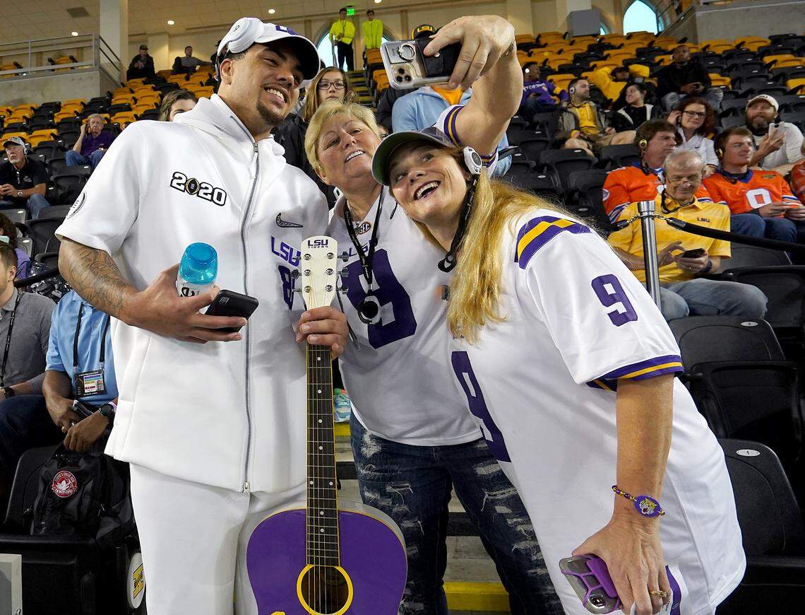 LSU tight end Thaddeus Moss, left, poses with two LSU fans during the team’s media day event Saturday in New Orleans. Moss has had the most prolific pass-catching season for a tight end in LSU history.