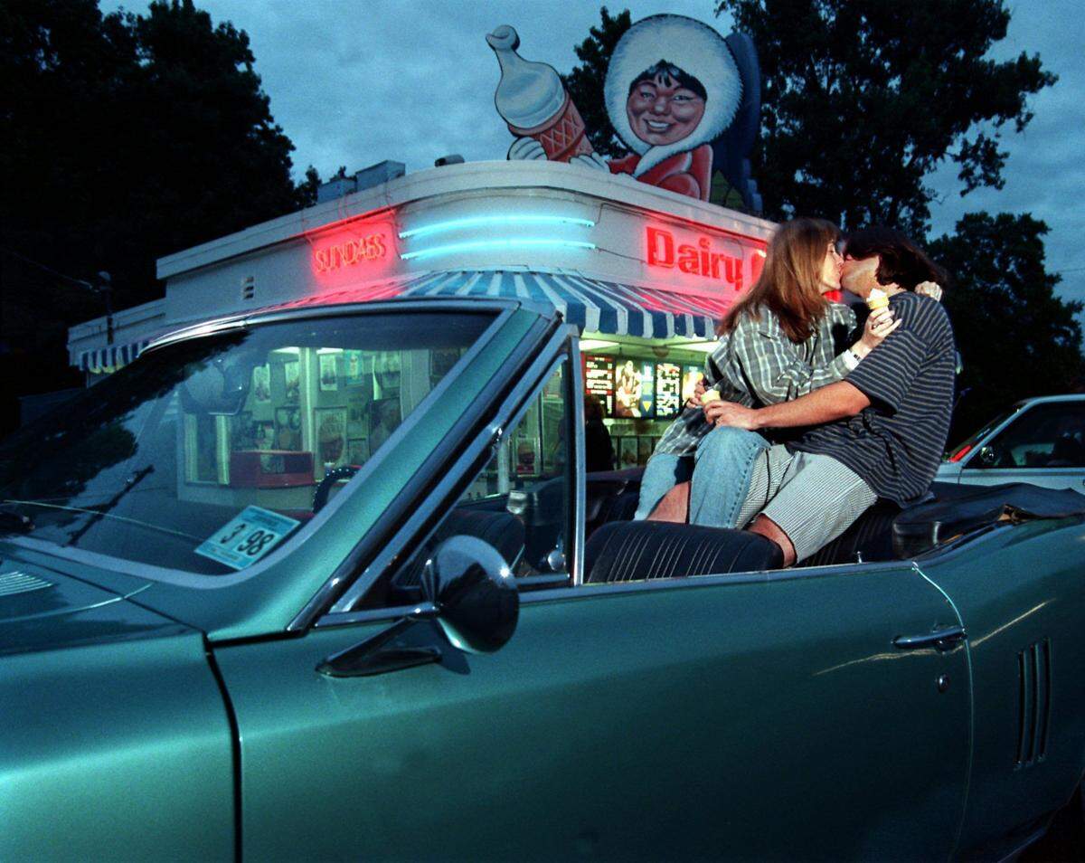 Tina and Steve Bernthal enjoy a kiss in the back of their 1967 Pontiac LeMans convertible at the Wilkinson Blvd. Dairy Queen in 1997.