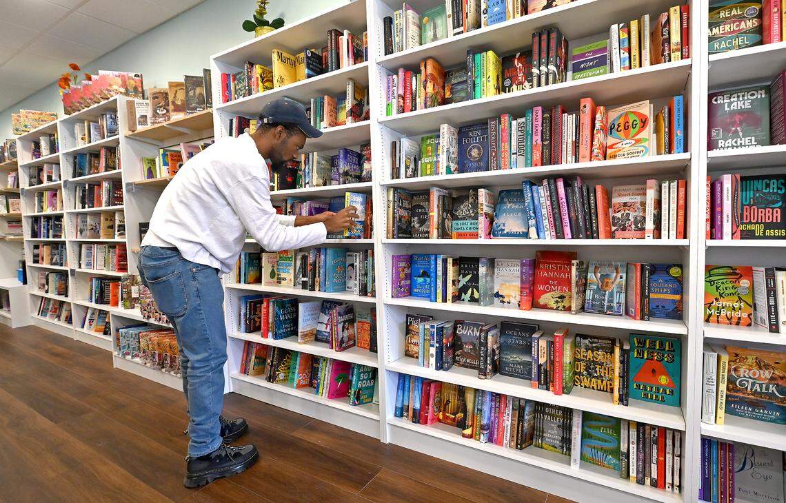 Daylen Jones, an employee at Troubadour Booksellers arranges a shelf.