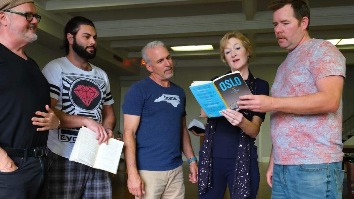 Paige Johnston Thomas works with Charlotte actors on a scene from “Oslo,” which won Tony, Drama Desk and New York Critics Circle awards in 2017 for best play. Thomas is directing “Oslo” for Three Bone Theatre in Charlotte. It opens May 23 at Spirit Square. Pictured left to right: Dennis Delamar, Mahbod Naimi, Victor Sayegh, Paige Johnston Thomas, and Peter Finnegan.