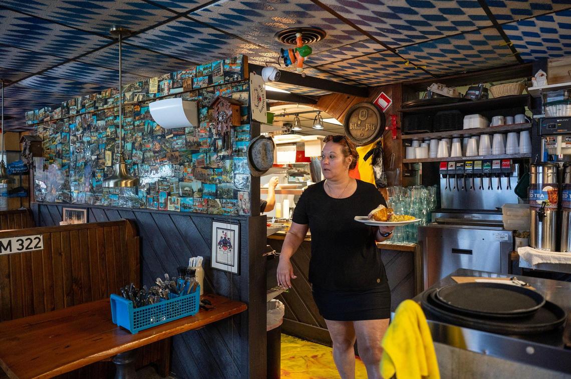 Ida De Zwaan delivers food to customers at Haus Heidelberg in Hendersonville last week. De Zwaan said 31 businesses in the county closed in May.