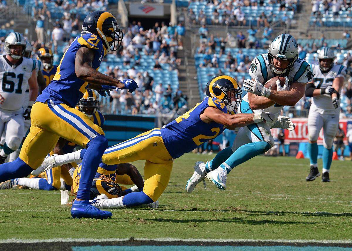 Empty seats can be seen in Bank of America Stadium as Carolina Panthers Christian McCaffrey fights for extra yardage against the Los Angeles Rams.