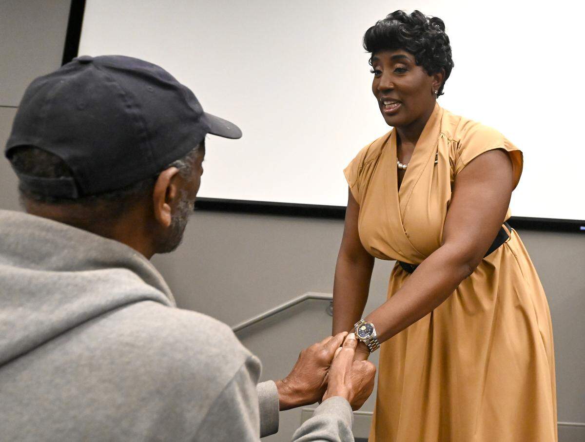 Charlotte City Council member Tiawana Brown, right, receives a handshake following a town hall meeting at Good Shepherd Church in Charlotte, NC on Wednesday, May 28, 2025. Brown was indicted on federal charges last week.