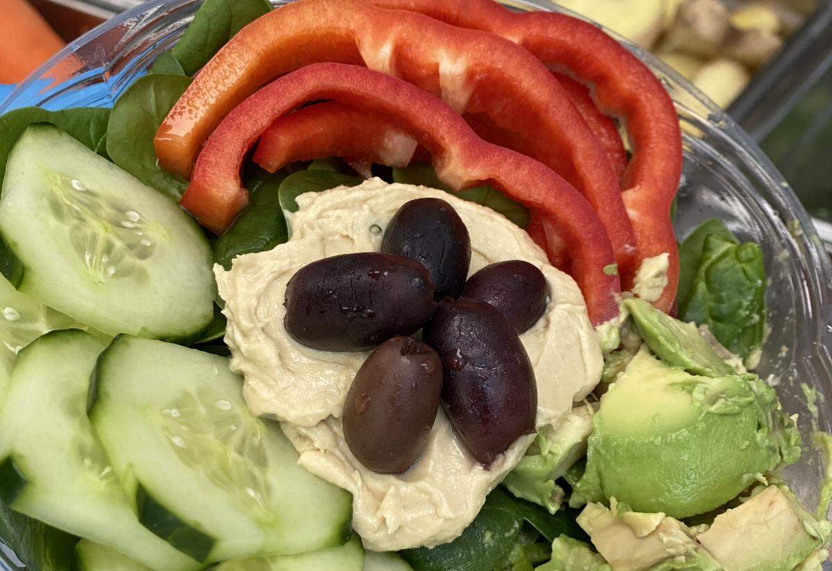 Exposed Vegan’s Kamala Bowl. includes spinach, hummus, avocado, red peppers, cucumber and olives.