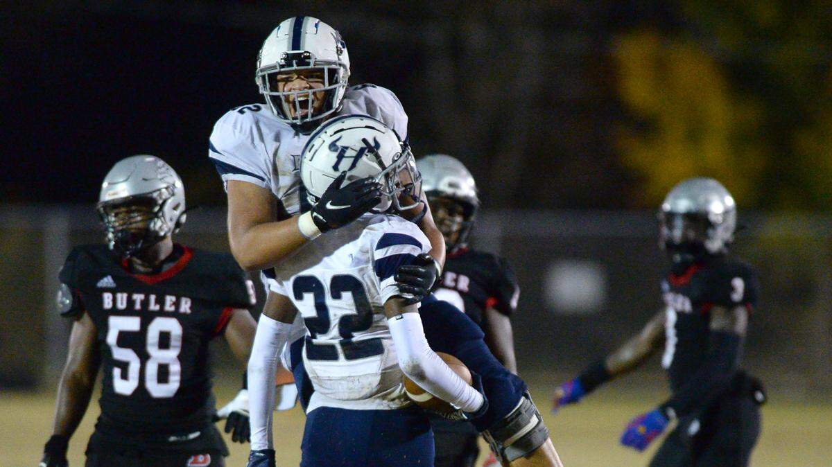 Hickory Ridge cornerback Amari Mastrofski, back to camera, is congratulated by a teammate following his interception of a pass by the Butler Bulldogs during first half action at Butler High School on Friday, November 4, 2022.