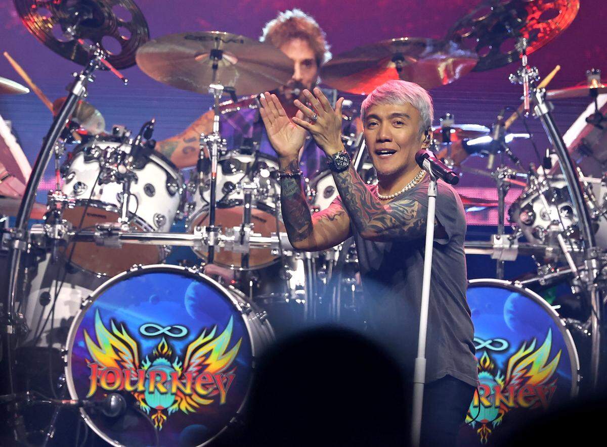 Journey lead vocalist Arnel Pineda, right, claps along with the audience as drummer Deen Castronovo, background, keeps time during one of the bands songs during the Final Frontier Tour at Spectrum Center in Charlotte, NC on Wednesday, May 20, 2026