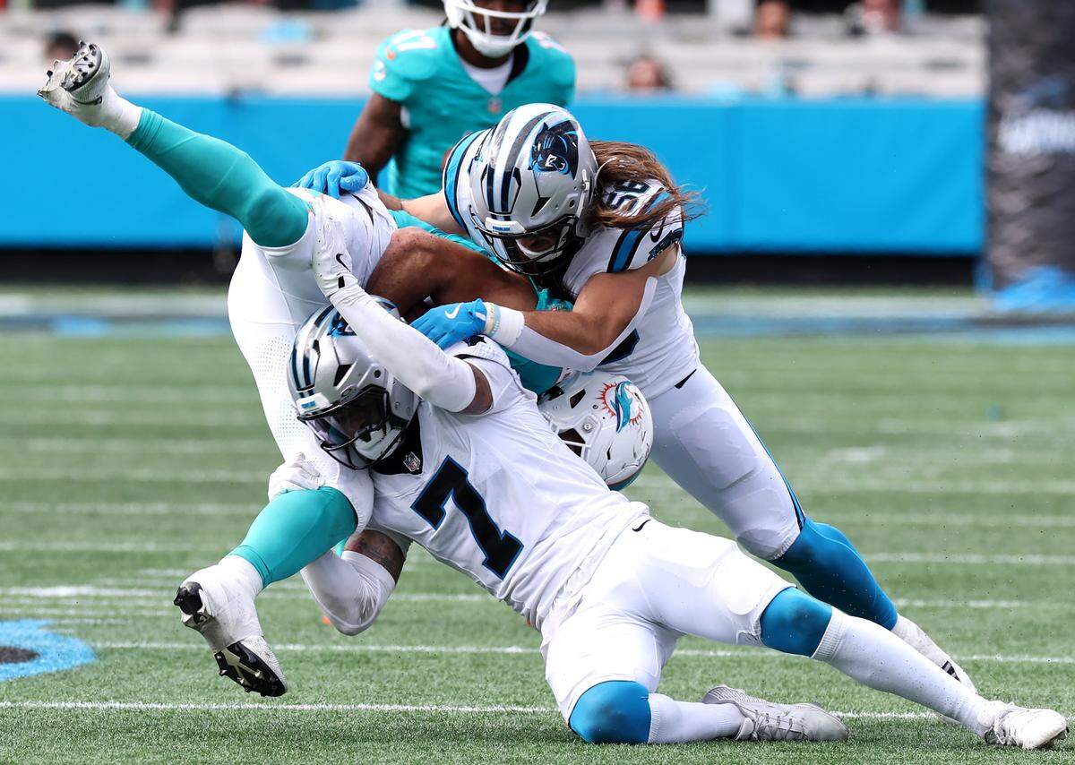 Carolina Panthers safety Tre'von Moehrig, center and linebacker Christian Rozeboom, right, upend a Miami Dolphins receiver on Sunday, October 5, 2025 at Bank of America Stadium in Charlotte, NC. The Panthers defeated the Dolphins 27-24.