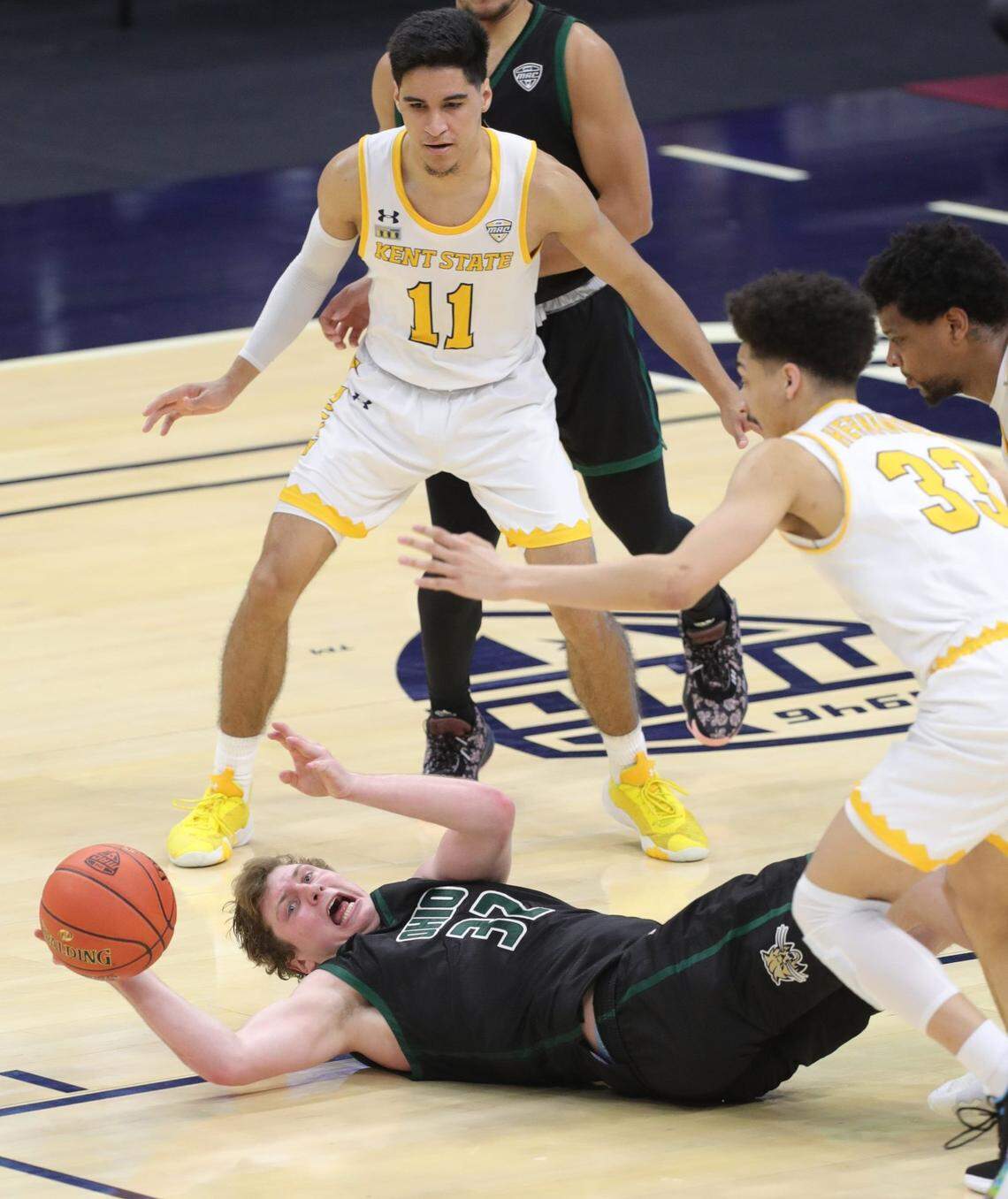 Ohio University’s Colin Granger scrambles to get the ball to a teammate during the second half between Kent’s Giovanni Santiago and Heremiah Hernandez, right, on Thursday, March 11, 2021 in Cleveland, Ohio, in a Mid-American Conference quarterfinal game at Rocket Mortgage Fieldhouse. The Bobcats won the game 85-62. [Phil Masturzo/ Beacon Journal] Ksu Hoops6