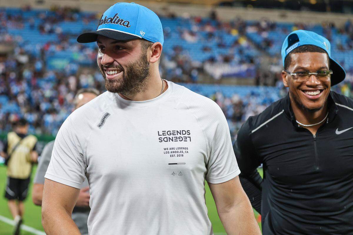 Panthers quarterback, Baker Mayfield left, and wide receiver, DJ Moore, walk the sidelines greeting fans ahead of the match between Charlotte FC and Chelsea FC at Bank of America Stadium on Wednesday, July 20, 2022 in Charlotte, NC.