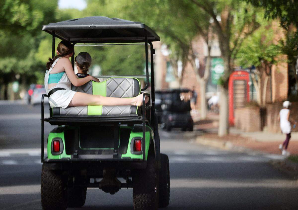 Residents of Baxter Village ride through a neighborhood Monday, June 9, 2025 in Fort Mill. New golf cart rules, signed by Gov. Henry McMaster on May 22, require passengers under 12 to wear seat belts on public roads, and drivers must be at least 16 years old to operate the recreational vehicles.
