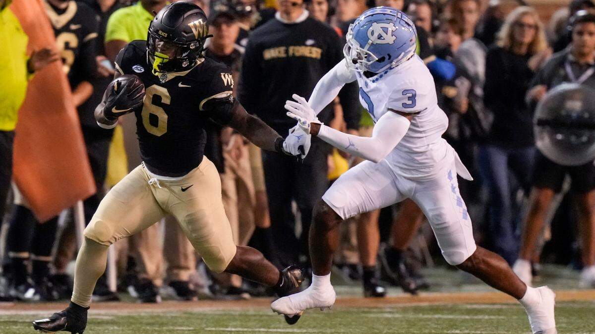 Wake Forest Demon Deacons running back Justice Ellison (6) tries to outrun North Carolina Tar Heels defensive back Storm Duck (3) during the first half at Truist Field.