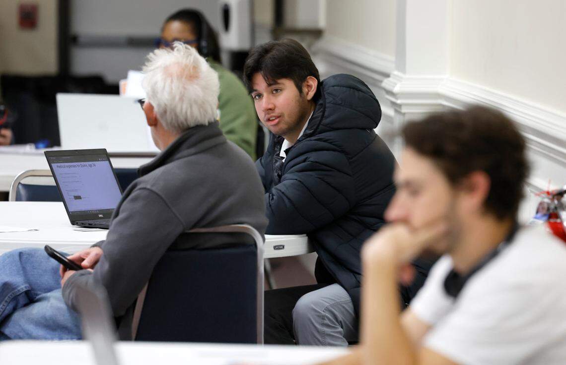 Kevin Ocampo, center right, helps a consumer with a Medicaid application during a Wake County ACA and Medicaid enrollment event at Martin Street Baptist Church in Raleigh, N.C., Friday, Dec. 1, 2023.